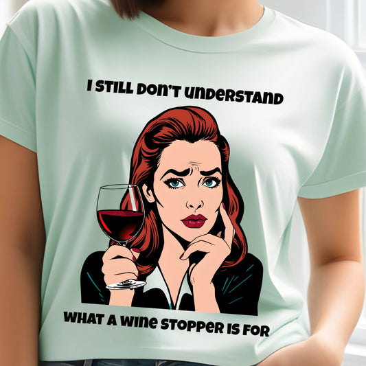 Light green t-shirt with a graphic of a woman holding a glass of wine and text, worn by a person.
